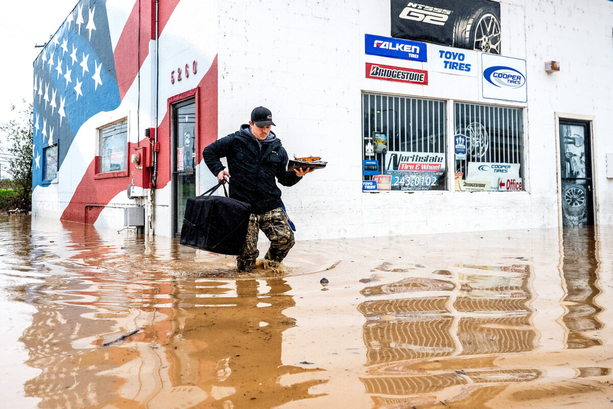 Dekoda Cruz walks through flood water while helping a friend who's tire shop flooded during heavy rains in Redding, Calif., on Dec. 22, 2025. (Noah Berger/AP Photo)