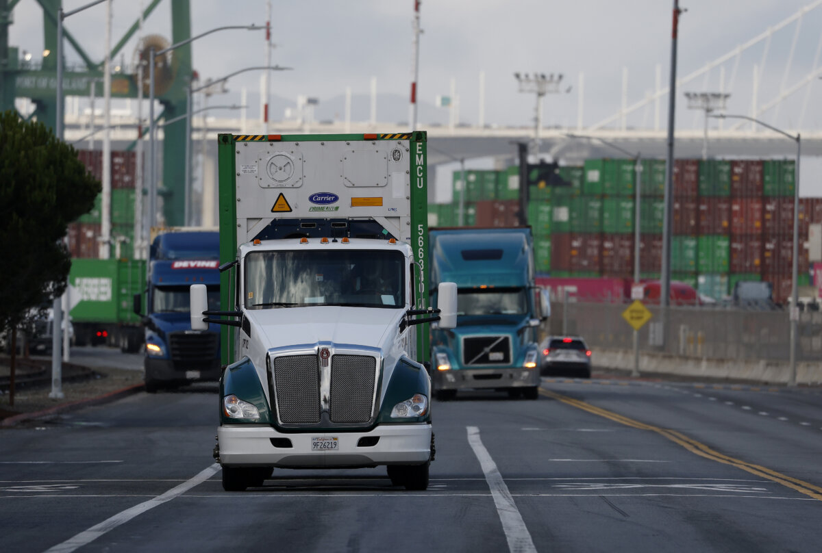 Trucks drive through the Port of Oakland on Nov. 14, 2025 in Oakland, Calif. The state is preparing to revoke 17,000 commercial driver's licenses that were issued to immigrants whose license expiration dates exceeded their legal U.S. stay. (Photo by Justin Sullivan/Getty Images)