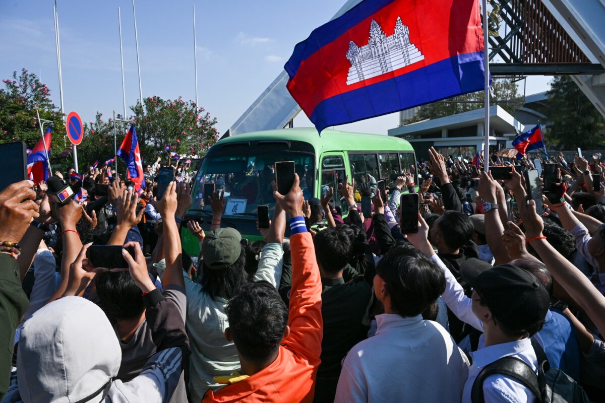 Cambodian people welcome soldiers, who had been captured by Thai soldiers in July, as a bus passes by as they leave the premises of the former international airport in Phnom Penh on Dec. 31, 2025. (Photo by Tang Chhin Sothy/AFP via Getty Images)