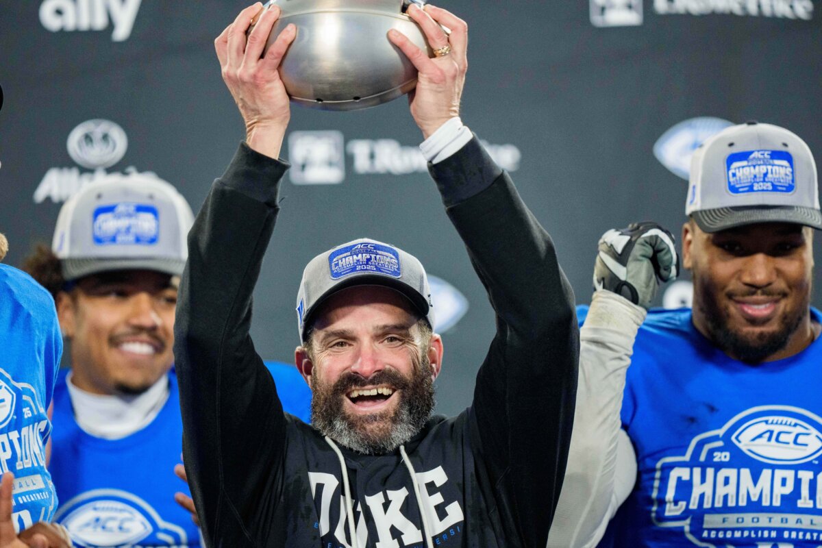 Duke head coach Manny Diaz holds up the trophy after defeating Virginia in the ACC championship game in Charlotte, N.C., on Dec. 6, 2025. (Jacob Kupferman/AP Photo)