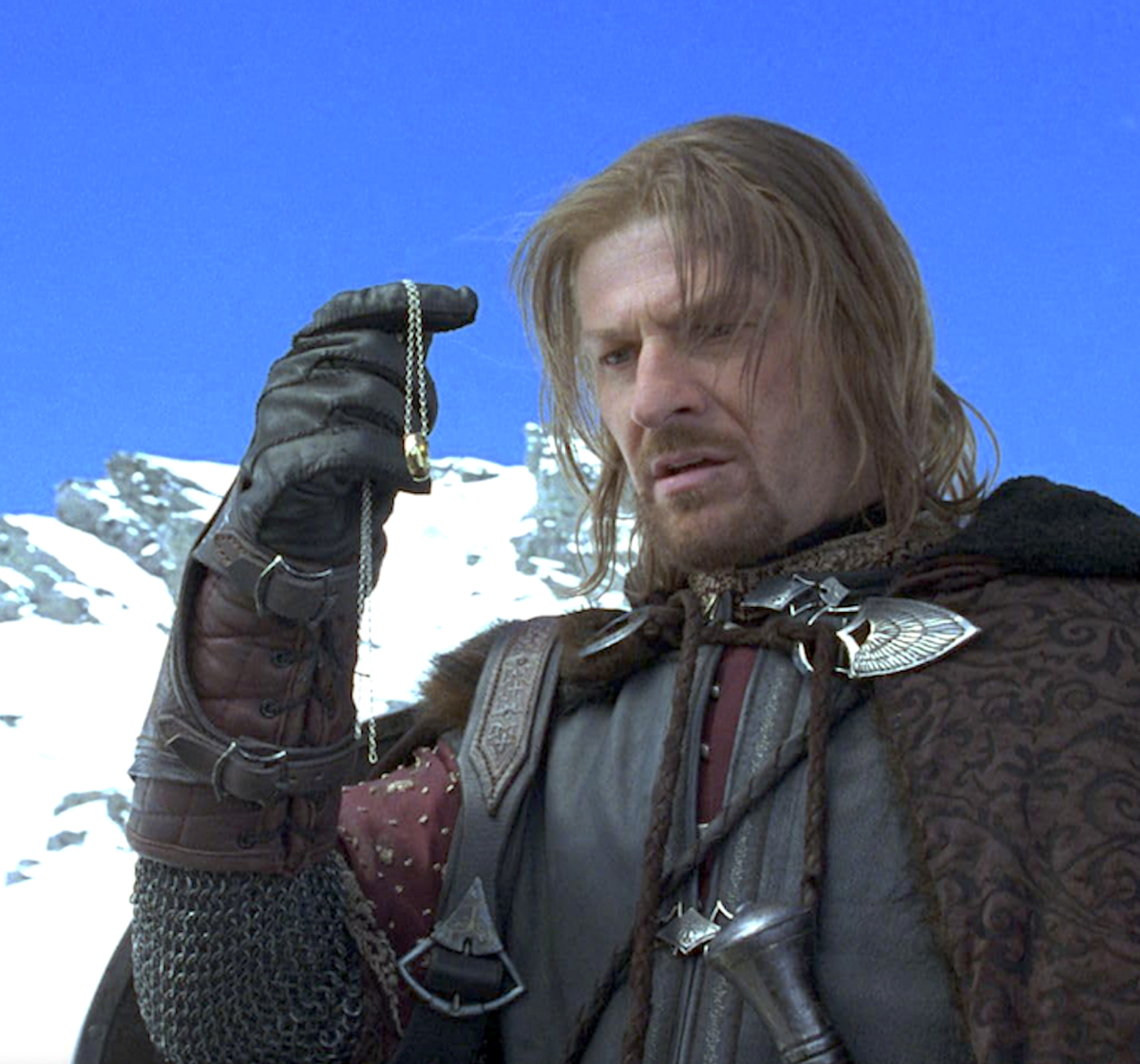 man standing on snowy mountain hold a ring on a chain, in The Lord of the Rings: The Fellowship of the Ring
