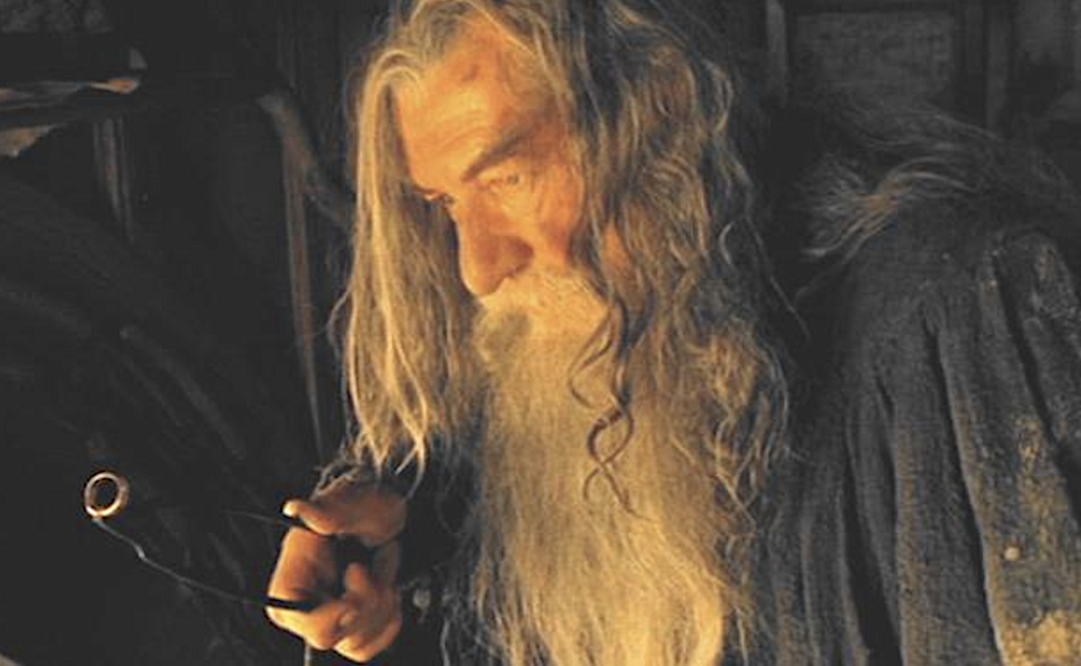 man with long white beard holds ring with tongs in The Lord of the Rings: The Fellowship of the Ring