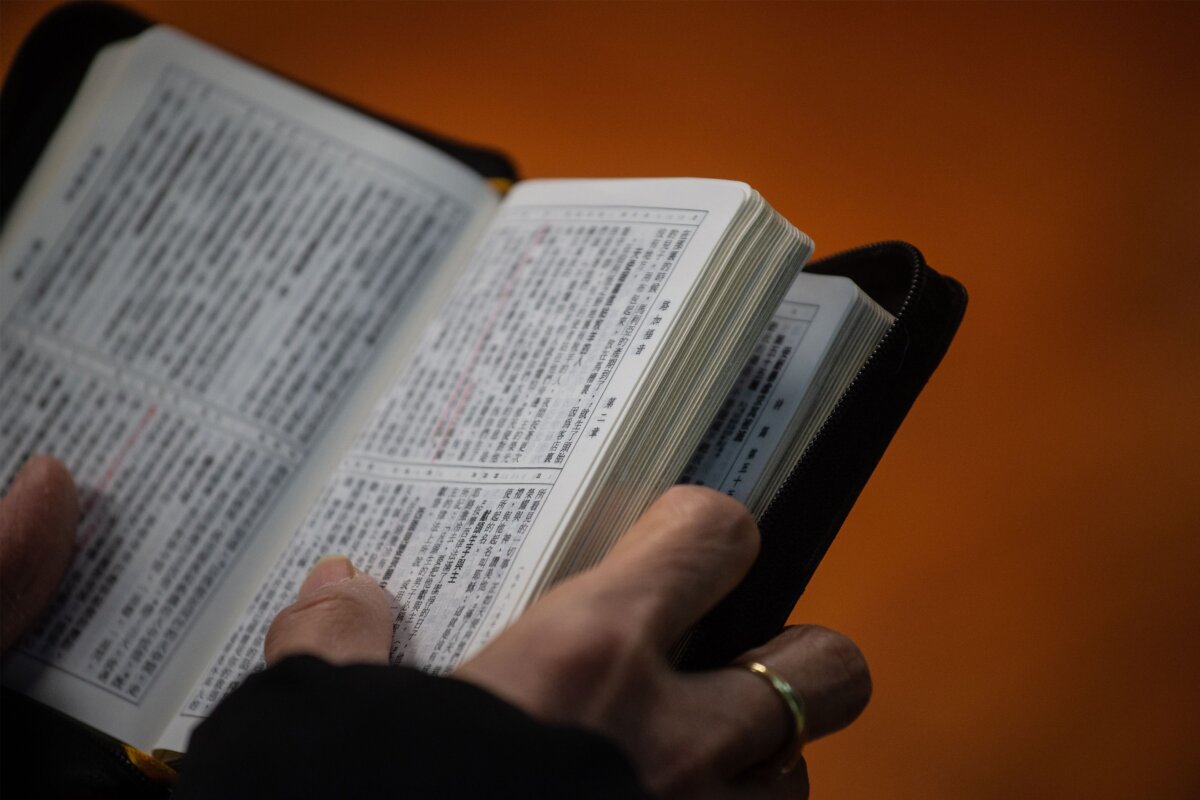 A worshipper holds a copy of the Bible while attending a church service ahead of Christmas in Hong Kong on Dec. 23, 2018, during which several members of the congregation wore black in support of underground churches in mainland China. (Philip Fong/AFP via Getty Images)