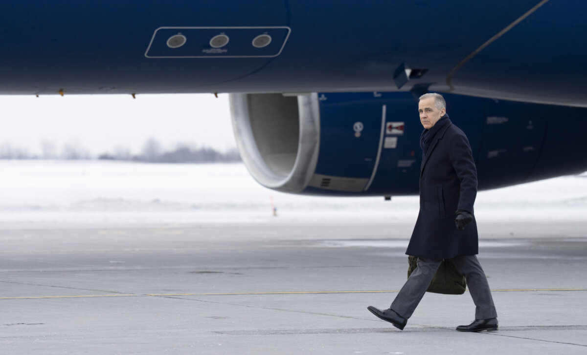 Prime Minister Mark Carney boards a government plane in Ottawa on Jan. 5, 2026. (The Canadian Press/Christinne Muschi)