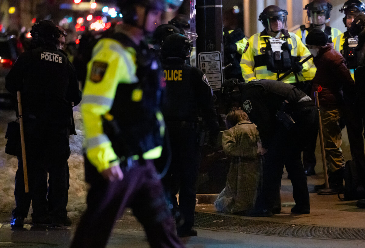 A protester against Immigration and Customs Enforcement operations is arrested by police officers in Minneapolis, Minn., on Jan. 9, 2026. (John Fredricks/The Epoch Times)