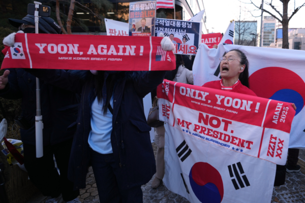 Supporters of former South Korean President Yoon Suk Yeol hold signs outside of Seoul Central District Court, in Seoul, South Korea, on Jan. 13, 2026. (Lee Jin-man/AP Photo/)