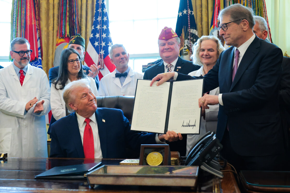 President Donald Trump (L) displays an executive order with Howard Kessler (R) that Trump signed in the Oval Office of the White House on Dec. 18, 2025, in Washington. During the ceremony, Trump signed the order reclassifying marijuana as a schedule III drug. (Anna Moneymaker/Getty Images)