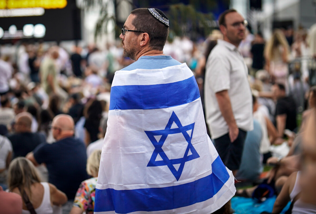A man wearing an Israeli national flag attends a memorial for the victims of the terrorist mass shooting at Bondi Beach in Sydney, Australia on Dec. 21, 2025. (Audrey Richardson/Getty Images)
