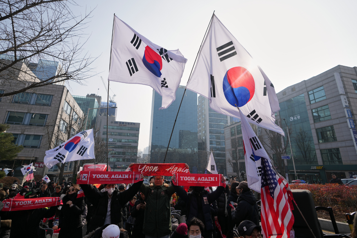 Supporters of former South Korean President Yoon Suk Yeol hold signs and flags outside Seoul Central District Court, in Seoul, South Korea, on Jan. 16, 2026. (Lee Jin-man/AP Photo)