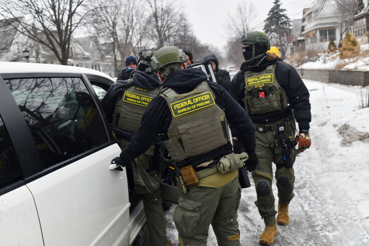 Federal agents return to their car after a patrol in the Frogtown neighborhood while anti-Immigration and Customs Enforcement (ICE) activists warn the community about their presence and oppose ongoing ICE detentions, part of heightened tensions following a federal immigration enforcement surge and recent shooting involving an ICE officer in St. Paul, Minn., on Jan. 16, 2026. (Octavio Jones/AFP via Getty Images)