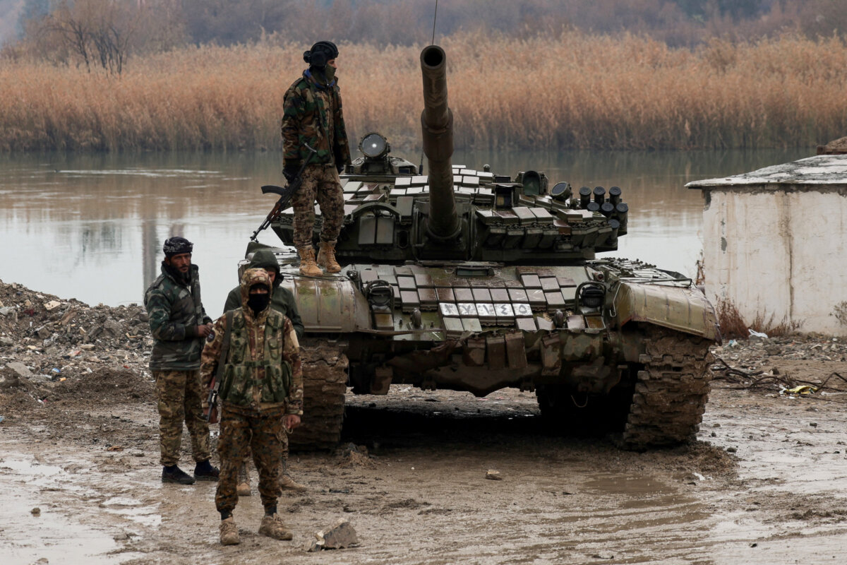 Military personnel stand at the crossing connecting the two banks of the Euphrates River, as others attempt to cross to the other side after the Syrian Democratic Forces (SDF) withdrew from Deir al-Zor province and the Syrian army took full control over the area, in Deir al-Zor, Syria, on Jan. 18, 2026. (Khalil Ashawi/Reuters)