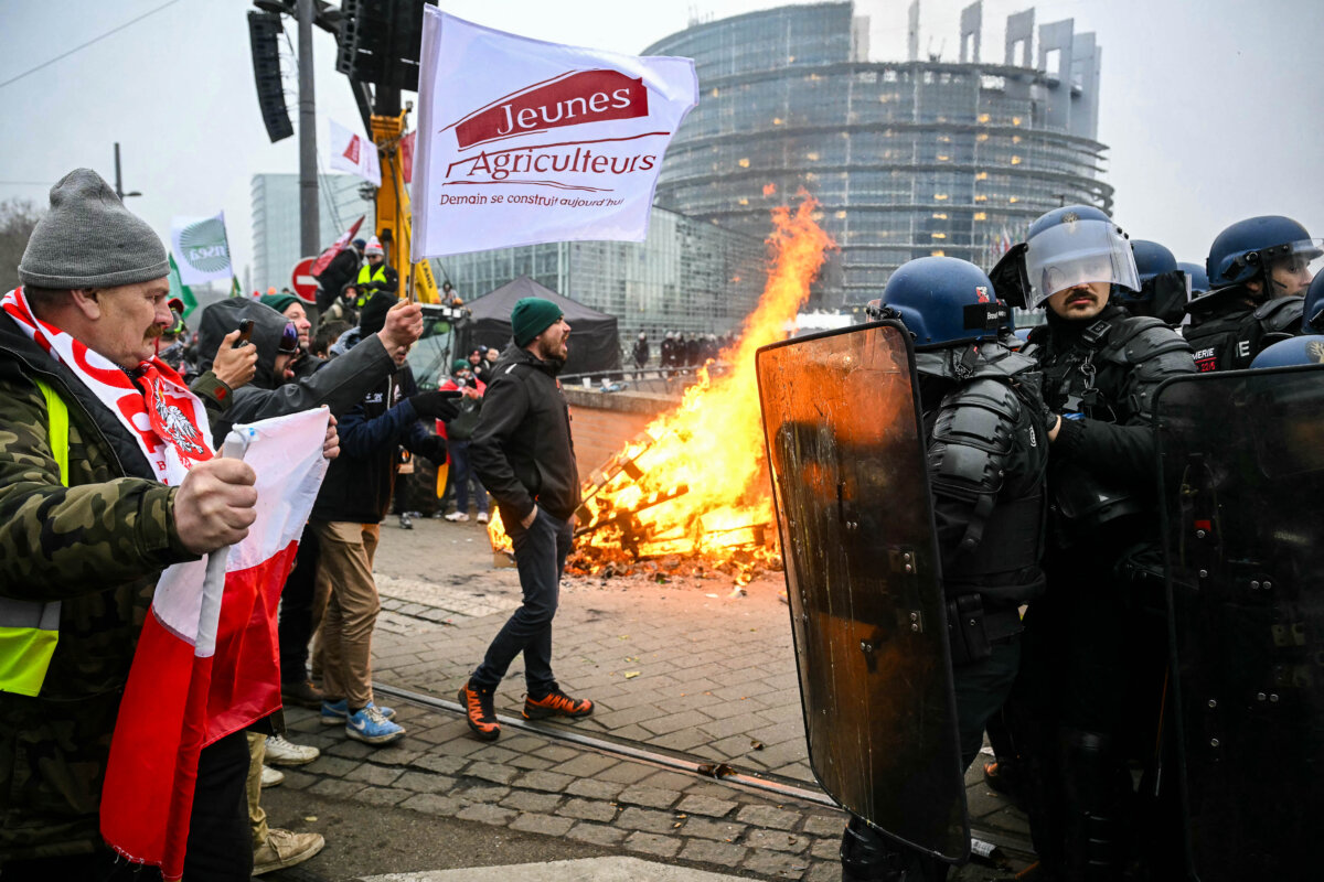 Protesters with the flags of Poland and the French farmers union face police in riot gear next to burning pallets outside the European Parliament during a rally against the free trade agreement between the European Union and the Mercosur countries in Strasbourg, France, on Jan. 20, 2026. The Mercosur consists of Argentina, Brazil, Paraguay, Uruguay, and Bolivia. (Nicolas Tucat/AFP via Getty Images)