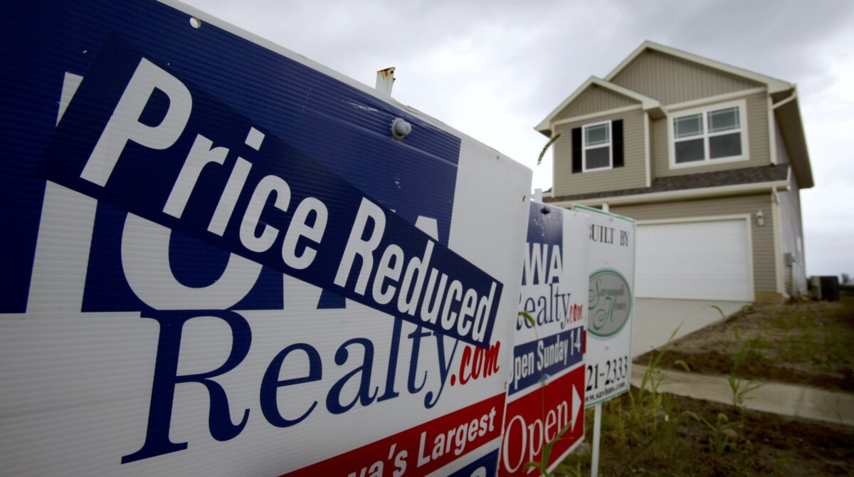 Signs stand in front of a new home for sale in a neighborhood in West Des Moines, Iowa, on Sept. 21, 2010. (AP Photo/Charlie Neibergall)