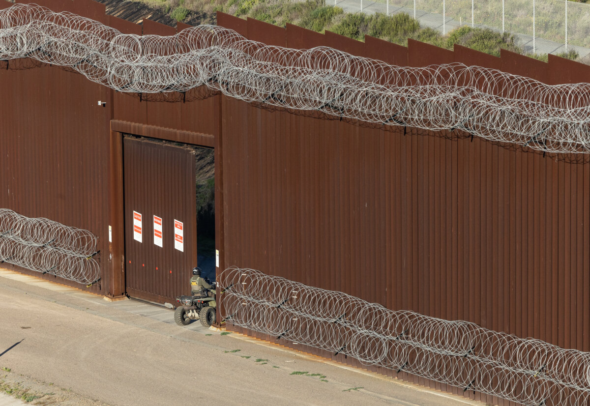 A United States Border Patrol agent enters through the United States border wall outside of San Diego, on Jan. 20, 2026. (John Fredricks/The Epoch Times)