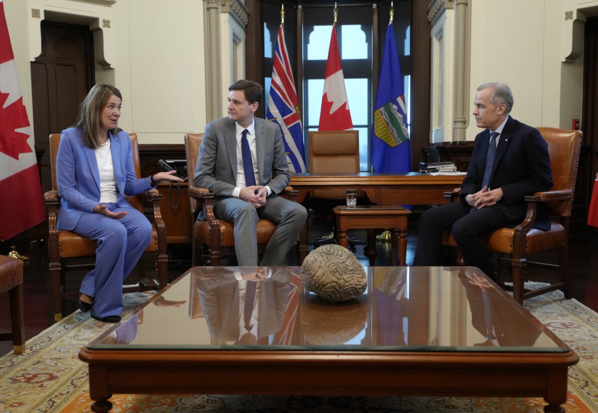 Prime Minister Mark Carney sits with Alberta Premier Danielle Smith and B.C. Premier David Eby at the start of a meeting in the prime minister's office in Ottawa on Jan. 28, 2026. (The Canadian Press/Adrian Wyld)