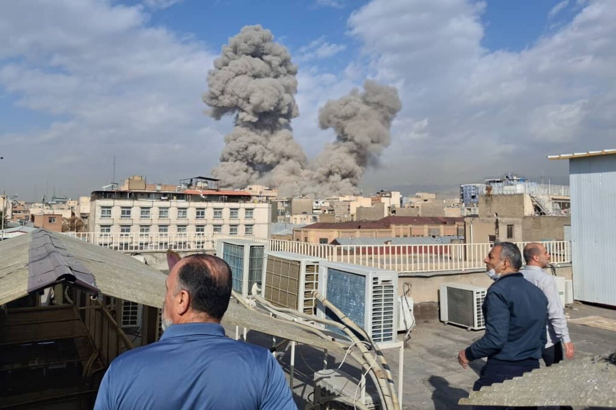 People watch as smoke rises on the skyline after an explosion in Tehran, Iran, on, Feb. 28, 2026. (AP Photo)