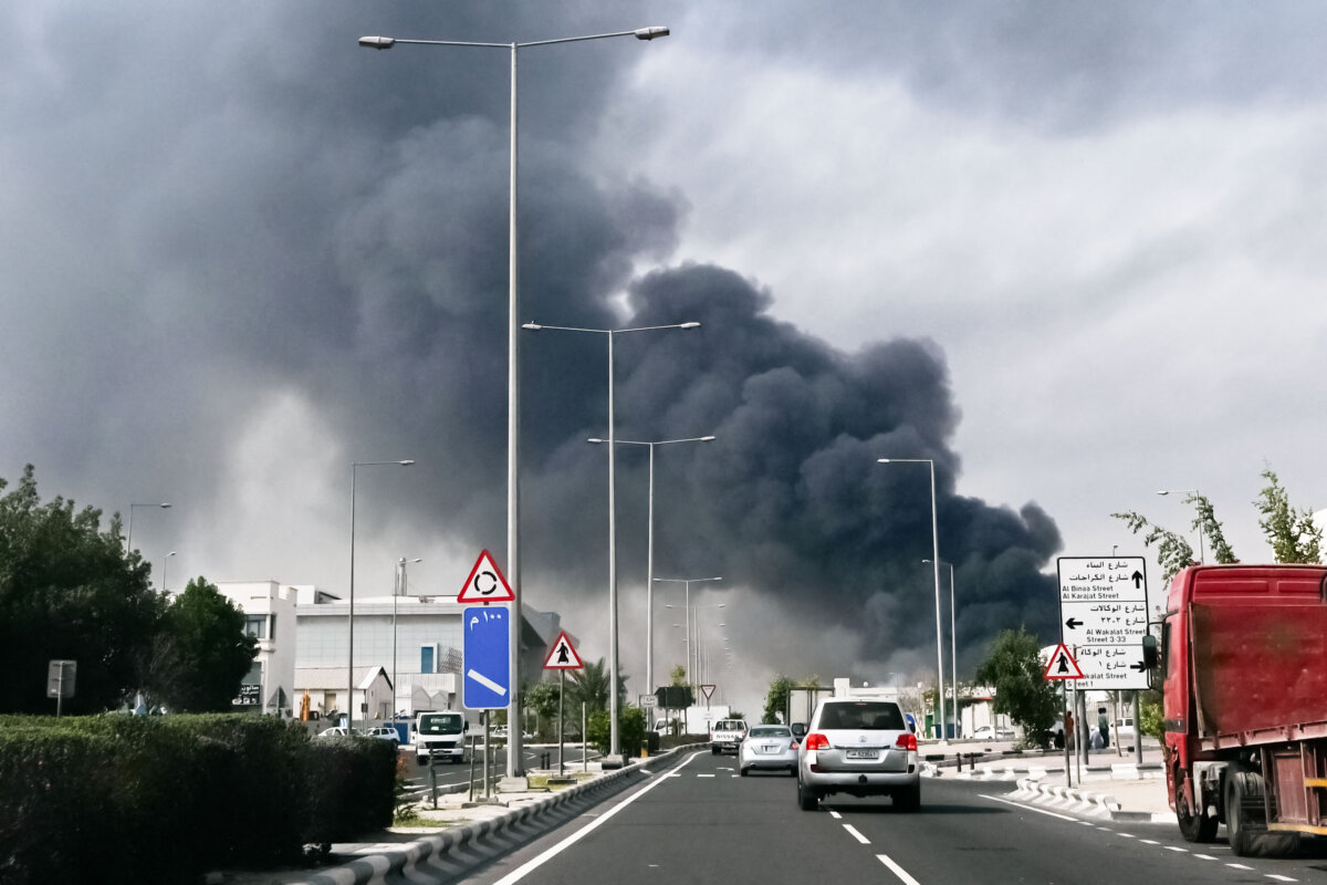 Motorists drive past a plume of smoke rising from a reported Iranian strike in the industrial district of Doha, Qatar, on March 1, 2026. (Mahmud HAMS/AFP via Getty Images)