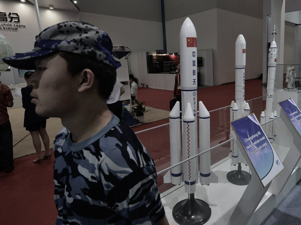 A security guard stands next to models of Chinese rockets on display at the 64th International Astronautical Congress in Beijing on Sep. 24, 2013. (Mark Ralston/AFP/Getty Images)