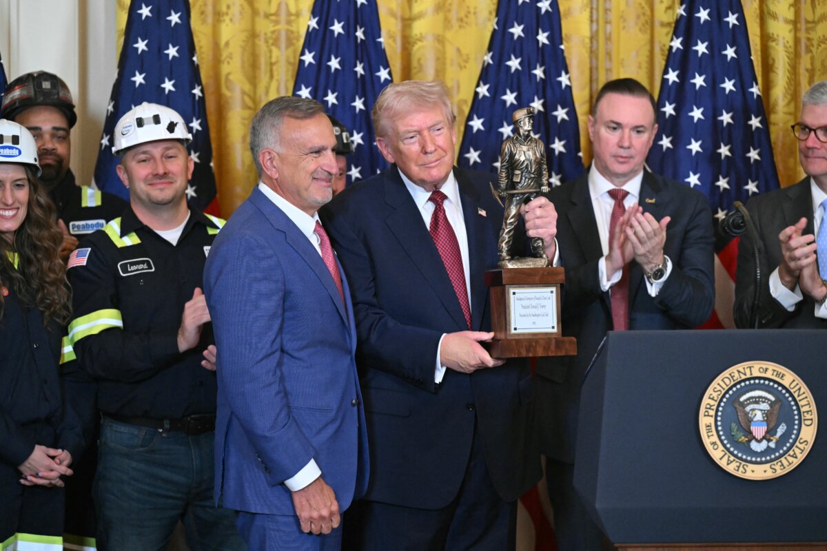 President Donald Trump (C) poses with "the Undisputed Champion of Beautiful Clean Coal" trophy handed to him by Jim Grech (L of center), CEO of Peabody Energy, at a "Champion of Coal" event at the White House on Feb. 11, 2026. (Saul Loeb/AFP via Getty Images)