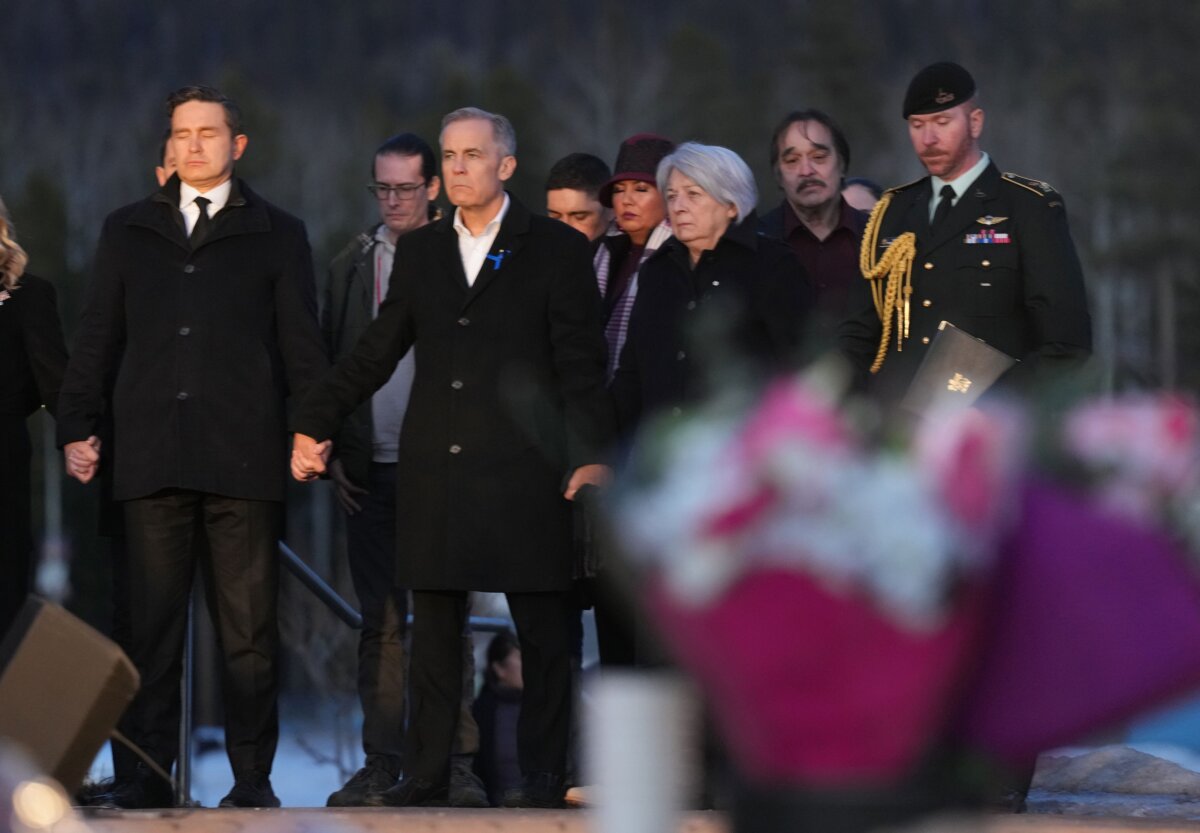(L–R) Conservative Leader Pierre Poilievre, Prime Minister Mark Carney, and Governor General Mary Simon join hands while attending a vigil for the victims of the Tumbler Ridge mass shooting, in Tumbler Ridge, B.C., on Feb. 13, 2026. (The Canadian Press/Christinne Muschi)