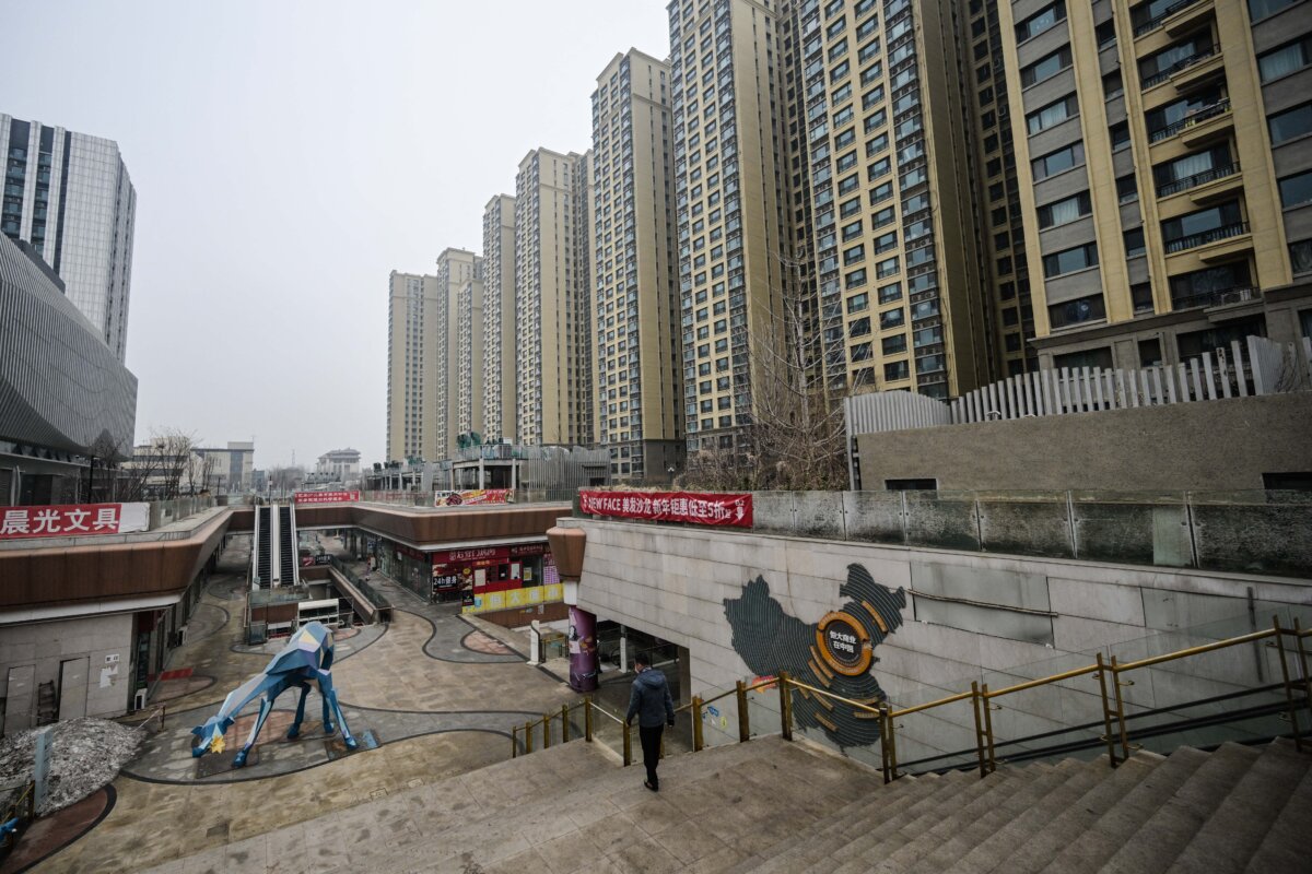 A man walks through a partially operating Evergrande commercial complex (L), next to an Evergrande residential compound (R) in Beijing on Jan. 30, 2024. (Pedro Pardo/AFP via Getty Images)