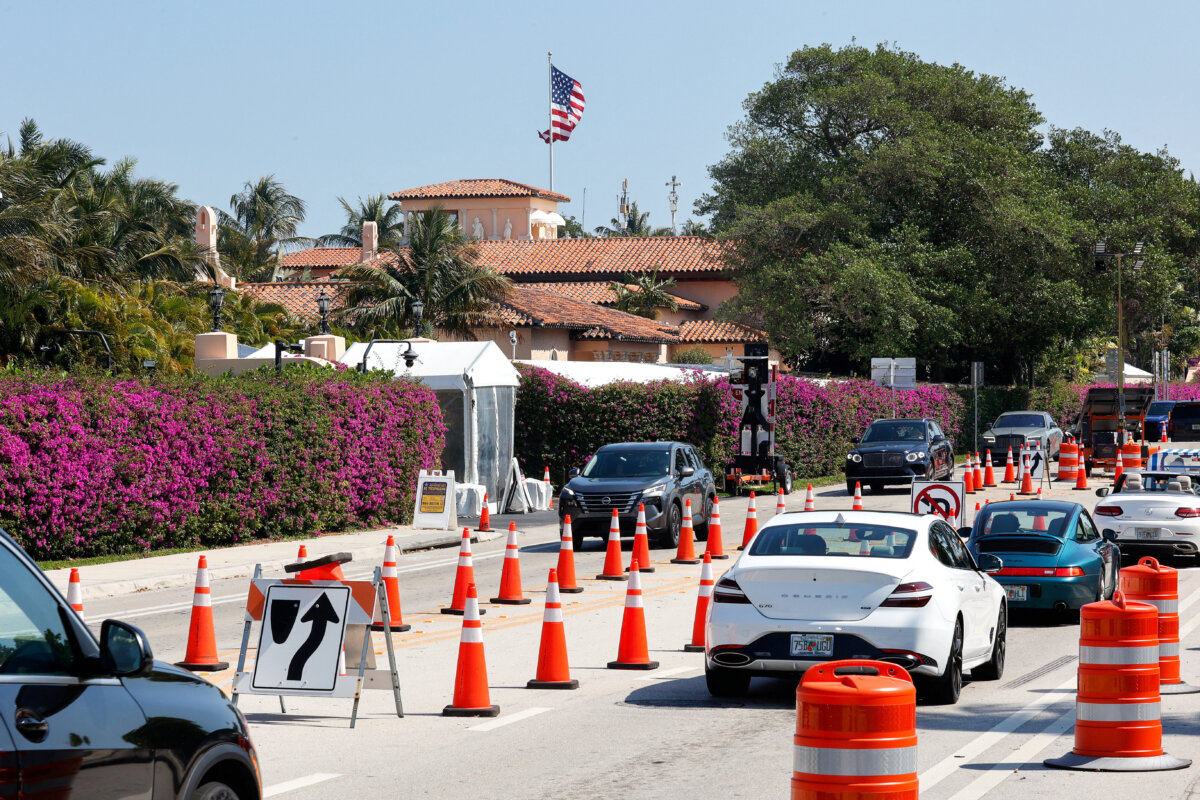 Cars drive by President Donald Trump's Mar-a-Lago resort, after U.S. Secret Service and local police shot and killed a man armed with a shotgun after he breached a secure perimeter of the resort in Palm Beach, Fla., on Feb. 22, 2026. (Marco Bello/Reuters)