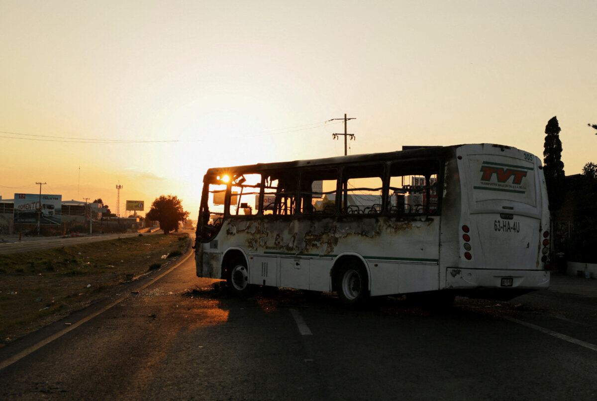 A burnt bus set up as a blockade by members of organized crime following a military operation in which Mexican officials said cartel boss Nemesio Oseguera, "El Mencho," was killed, at a tourist area, in Zapopan, Mexico, on Feb. 22, 2026. (Gabriel Trujillo/Reuters)