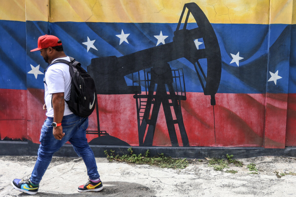 A man walks past a mural depicting an oil pumpjack on a Venezuelan flag, in Caracas, Venezuela, on Jan. 15, 2026. (Pedro Mattey/AFP via Getty Images)
