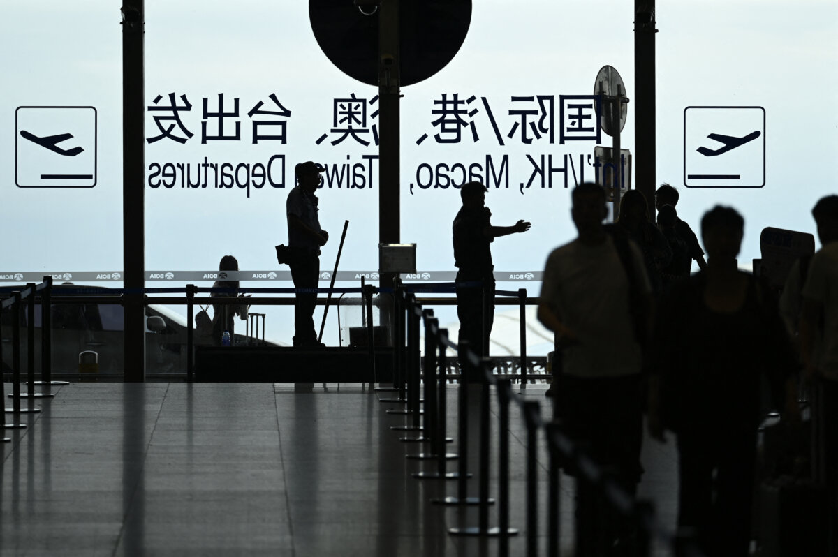 A security guard guides passengers at Beijing Capital International Airport on July 6, 2025. (Wang Zhao/AFP via Getty Images)