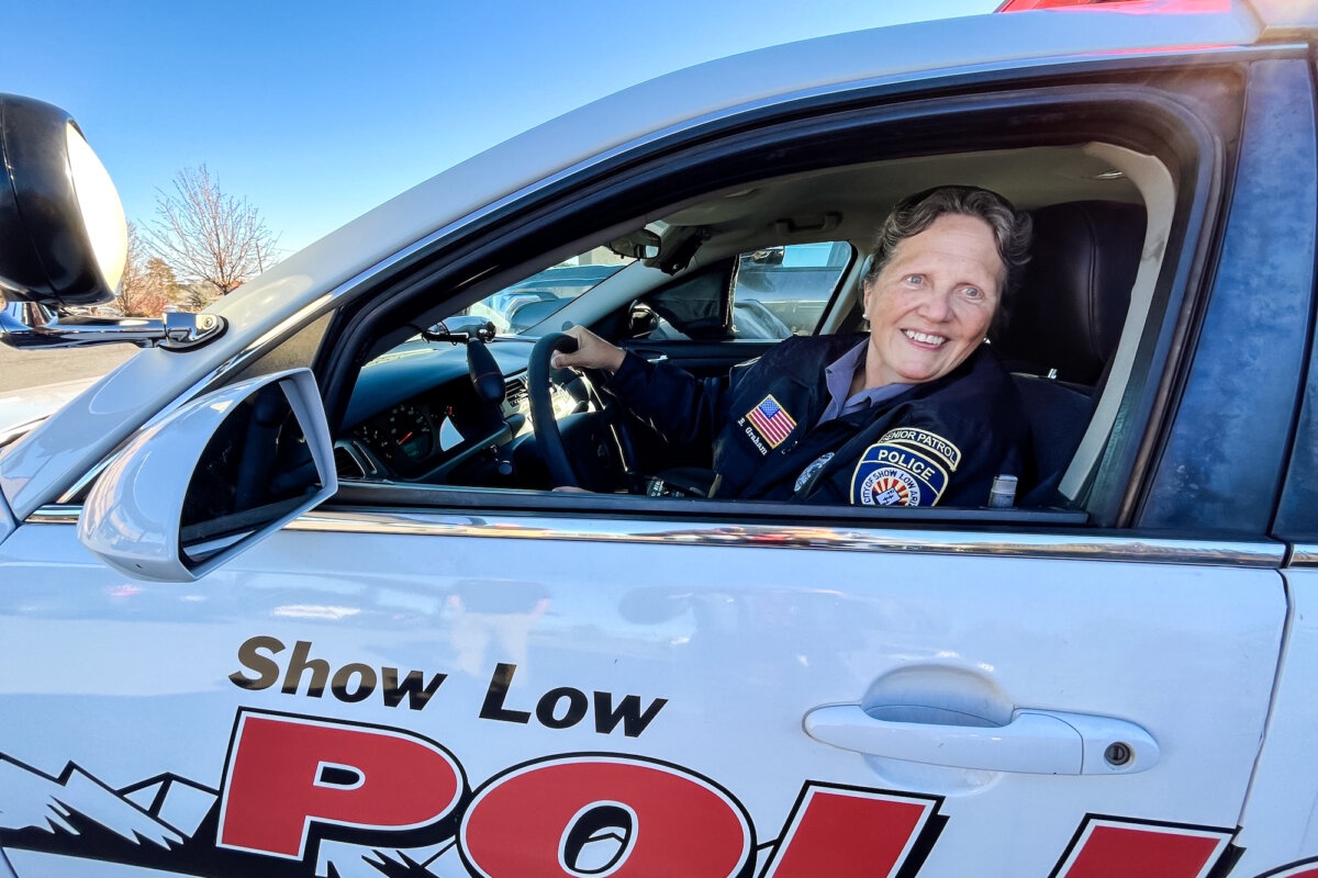 Beverly Graham, a member of the Senior Patrol, sits behind the wheel of her police cruiser in Show Low, Ariz., on Feb. 4, 2026. (Allan Stein/The Epoch Times)