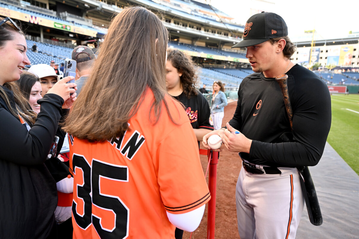 Adley Rutschman of the Baltimore Orioles signs autographs before a game against the Washington Nationals at Nationals Park in Washington on April 18, 2023. (Greg Fiume/Getty Images)