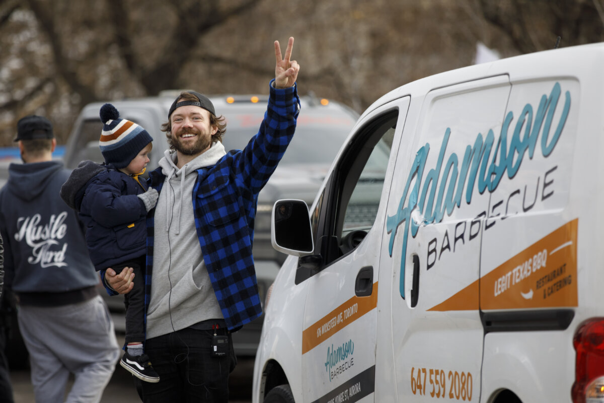 Adamson Barbecue owner Adam Skelly gives a peace sign to media at his restaurant in Etobicoke, Ont., on Nov. 24, 2020. (The Canadian Press/Cole Burston)