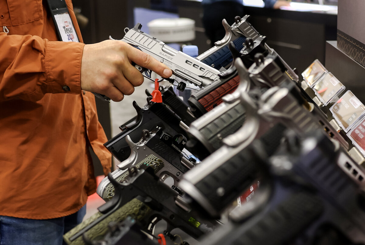 A visitor inspects a gun at the National Rifle Association Annual Meeting & Exhibits at the Kay Bailey Hutchison Convention Center in Dallas on May 17, 2024. (Justin Sullivan/Getty Images)