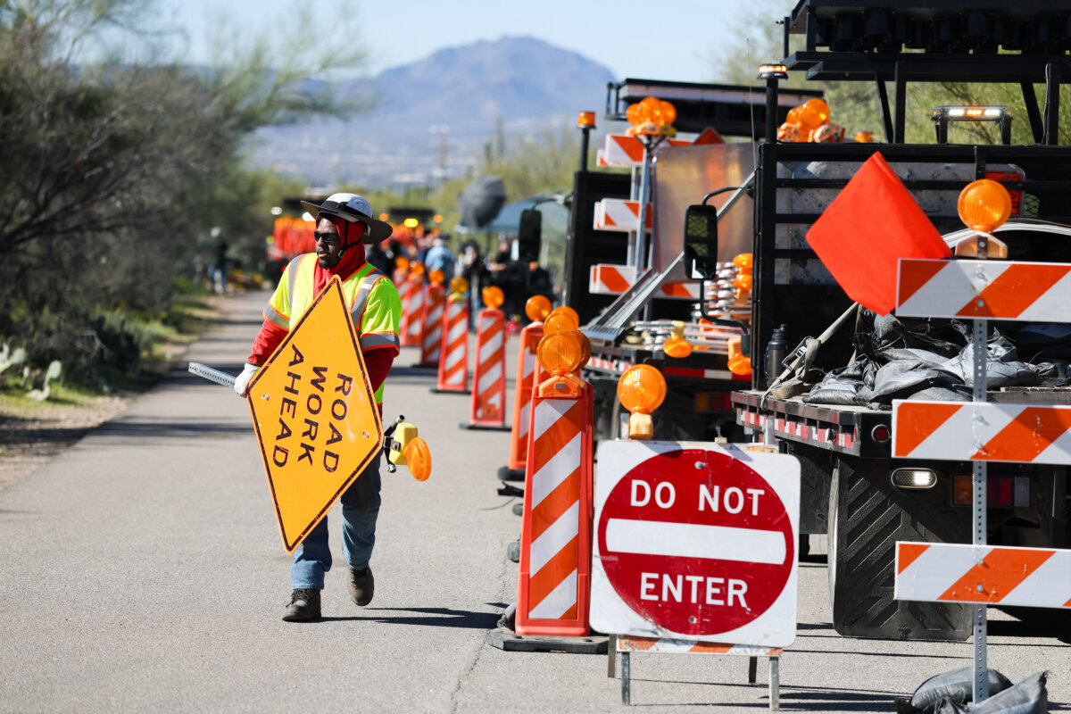 A road crew sets up signs and barricades in front of Nancy Guthrie's residence to turn the two-lane road into a one-lane road in Tucson, Ariz., on Feb. 21, 2026. (Joe Raedle/Getty Images)