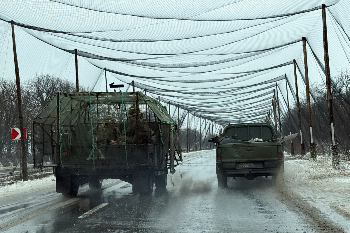 Service members of the 93rd Kholodnyi Yar Separate Mechanized Brigade of the Ukrainian Armed Forces ride a military vehicle along a road covered with anti-drone net near the frontline town of Kostiantynivka in Donetsk region, Ukraine, on Feb. 19, 2026. (Stringer/Reuters)
