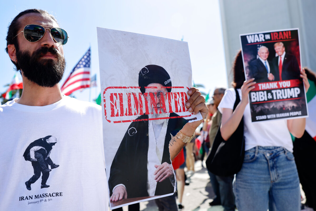 A man holds a picture of Iranian leader Ayatollah Ali Khamenei reading "ELIMINATED" as members of the Iranian community and supporters celebrate in Los Angeles on Feb. 28, 2026. (Mario Tama/Getty Images)