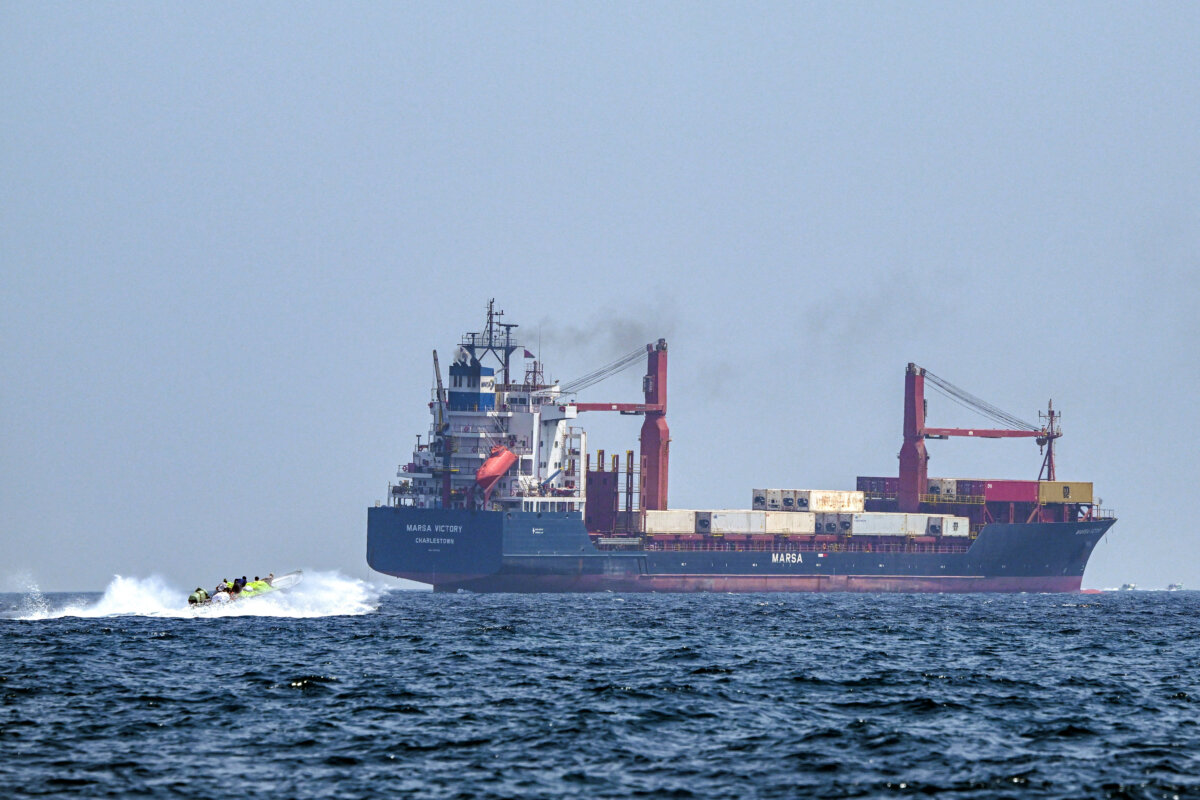 A boat approaches the Saint Kitts and Nevis-flagged container ship Marsa Victory while cruising in the waters of the Strait of Hormuz off the coast of Khasab in Oman's northern Musandam Peninsula on June 25, 2025. (Giuseppe Cacace/AFP via Getty Images)