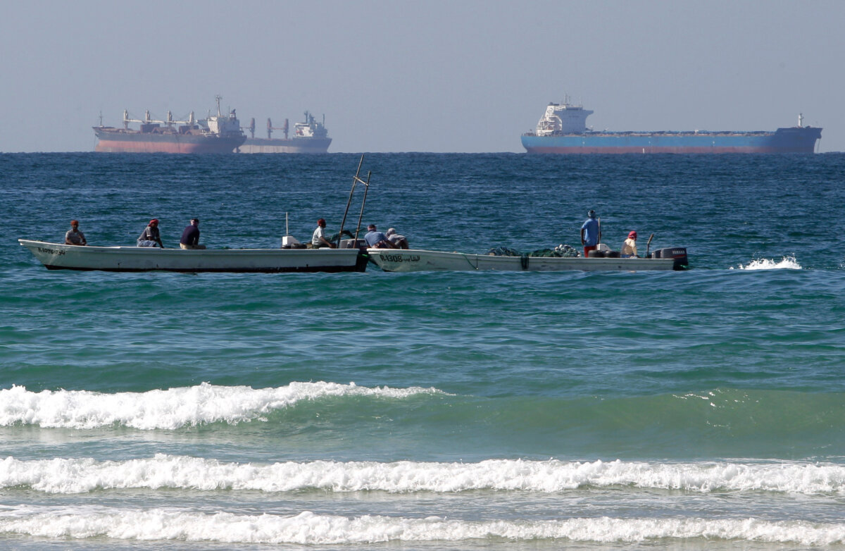 Fishermen work in front of oil tankers south of the Strait of Hormuz Jan. 19, 2012. (Kamran Jebreili/AP Photo)