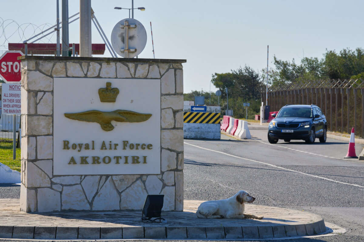 A dog sits at the main gate of the U.K.’s RAF Akrotiri air base after it was hit by a drone strike early morning near Limassol, Cyprus, Monday, March, 2, 2026. (AP Photo/Petros Karadjias)