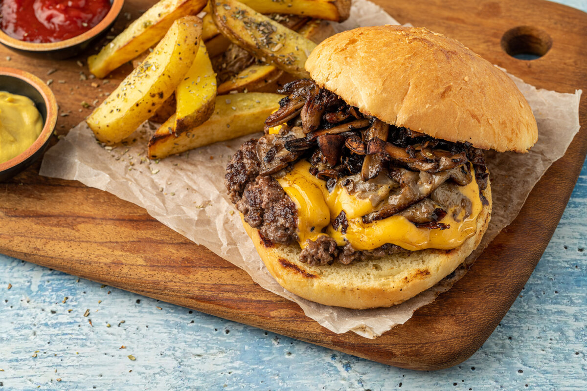 Mountains of onions pressed into sizzling beef created a burger that's become a regional icon. (yalcinsonat1/Getty Images)