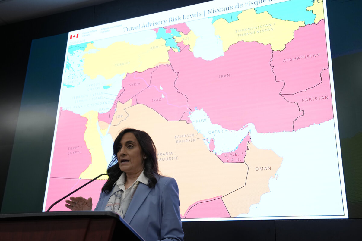 A map showing travel advisory risk levels in the Middle East is shown behind Minister of Foreign Affairs Anita Anand as she speaks at a news conference at the Emergency Watch and Response Centre at Global Affairs Canada in Ottawa, on March 4, 2026. (The Canadian Press/Justin Tang)