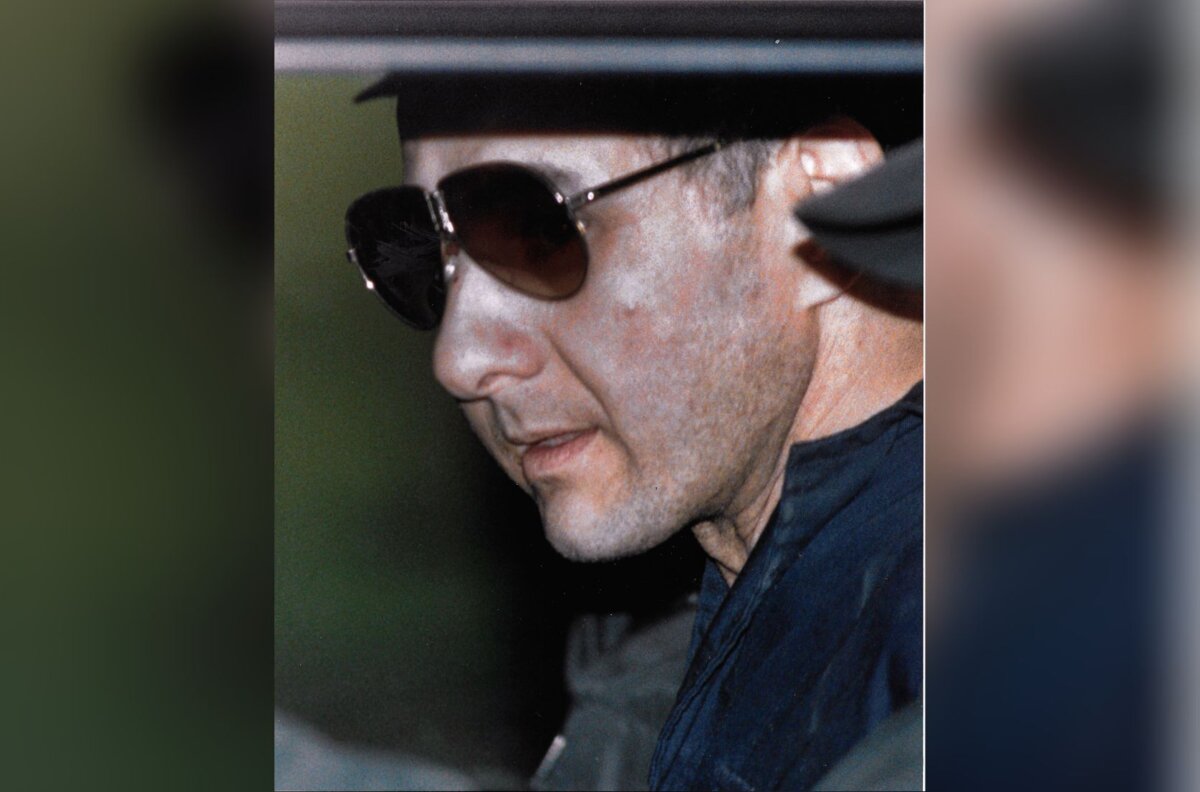 Allan Legere is escorted from the RCMP detachment in Miramichi, N.B on Nov. 24, 1989 after being arrested earlier in the day. (The Canadian Press/Andrew Vaughan)