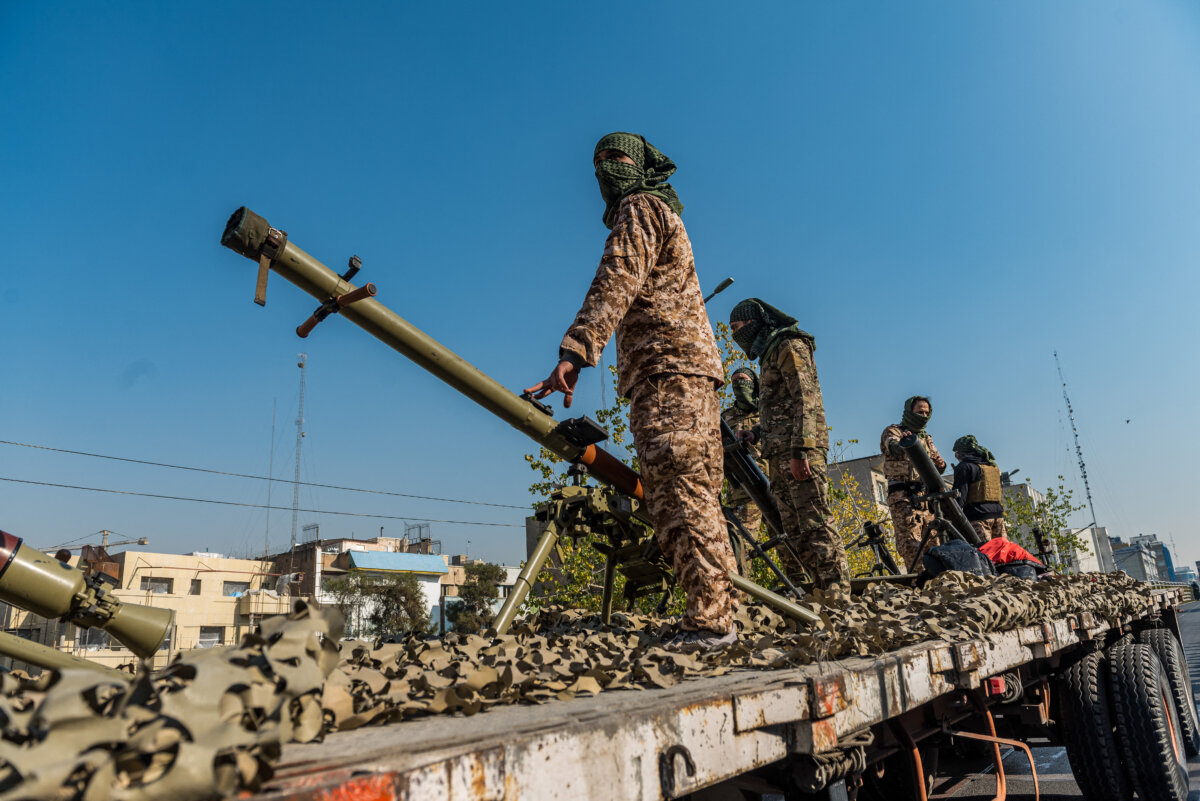 Masked IRGC members stand beside rocket and artillery launchers on the back of a truck during a parade in downtown Tehran, Iran, on Jan. 10, 2025. (Hossein Beris / Middle East Images / Middle East Images via AFP)