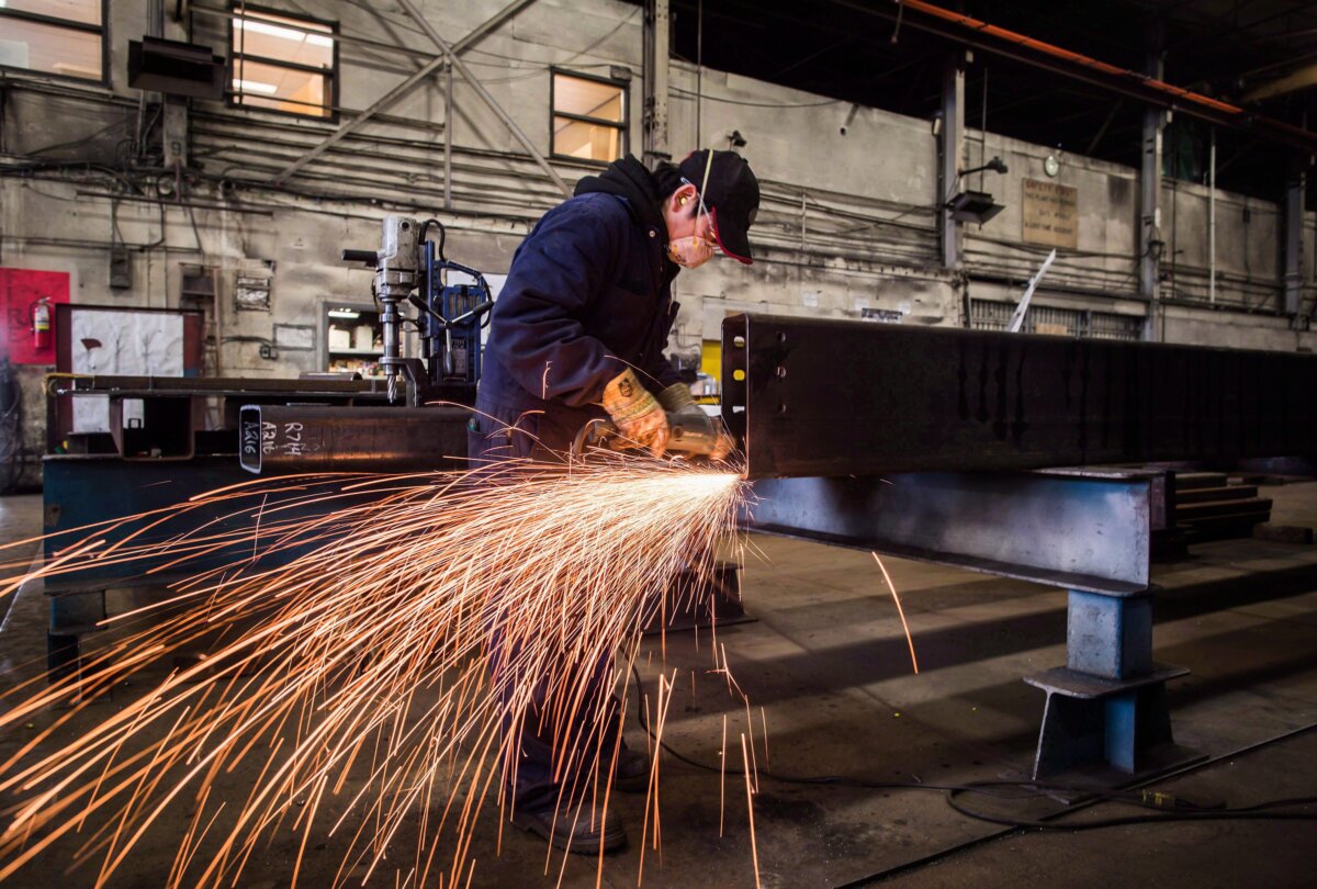 A worker uses a grinder on a steel at a factory in Burnaby, B.C., in a file photo. (The Canadian Press/Darryl Dyck)