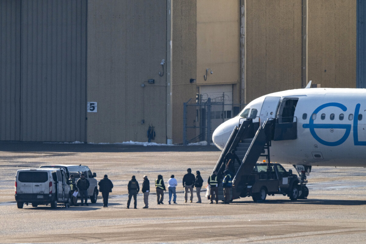 ICE agents look on as detainees board a plane at Minneapolis-St. Paul International Airport on Feb. 24, 2026. (Stephen Maturen/Getty Images)