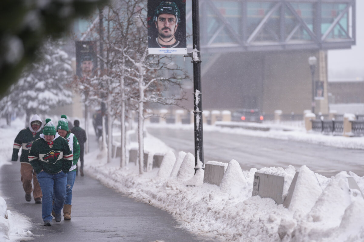 Fans walk through snowy streets before an NHL hockey game between the Minnesota Wild and Toronto Maple Leafs, in St. Paul, Minn., on March 15, 2026. (Abbie Parr/AP Photo)