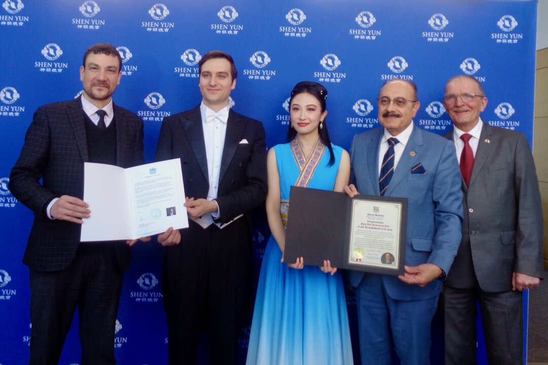 Mississauga Deputy Mayor John Kovac (L) presents his letter of appreciation to Shen Yun’s hosts Daniel Khmelev and Nancy Zhang at the Living Arts Centre in Mississauga, Ont., on March 14, 2026. Ontario MPP Sheref Sabawy (2nd R) and former MP Wladyslaw Lizon (R) also attended the March 14 Shen Yun performance. (NTD)