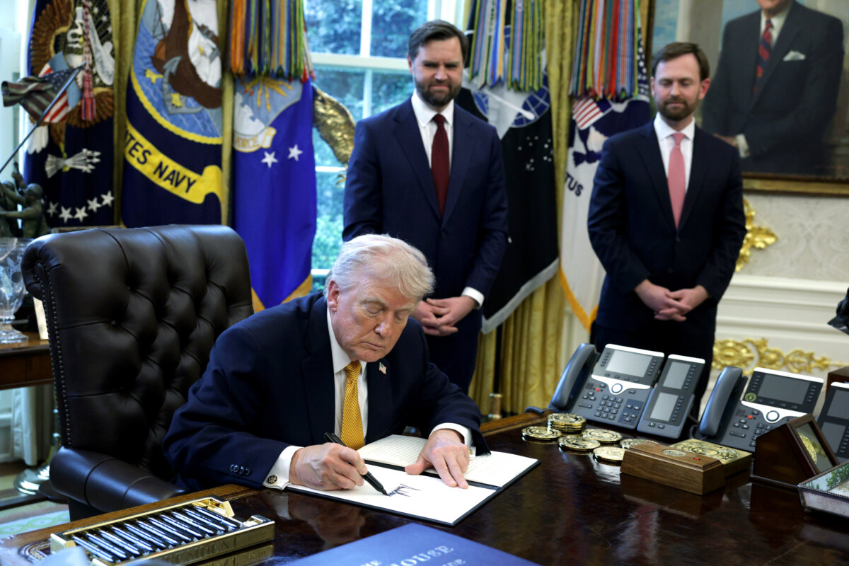 President Donald Trump signs an executive order as Vice President JD Vance (2nd L) and Federal Trade Commission Chairman Andrew Ferguson (R) look on during a White House signing ceremony in the Oval Office of the White House on March 16, 2026. (Alex Wong/Getty Images)