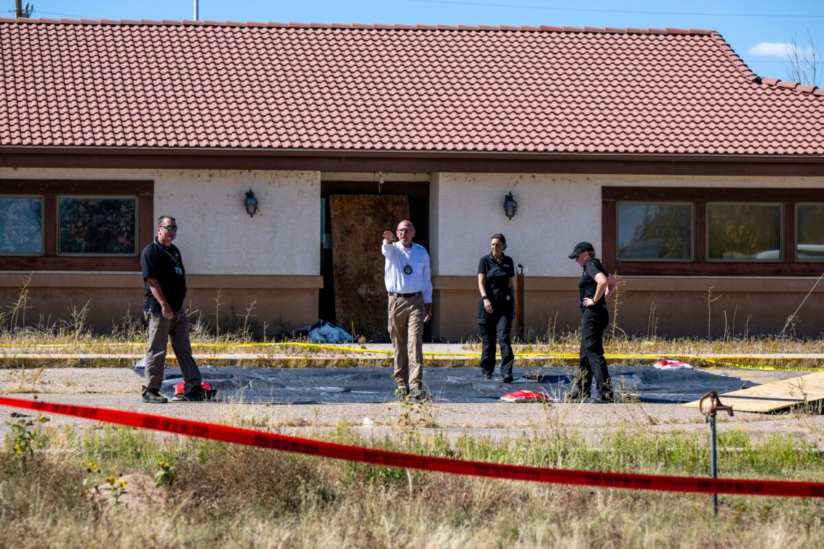 Fremont County coroner Randy Keller (C), and other authorities survey the area where they plan to put up tents at the Rturn to Nature Funeral Home where over 100 bodies have been improperly stored in Penrose, Colo., on Oct. 7, 2023. (Parker Seibold/The Gazette via AP)