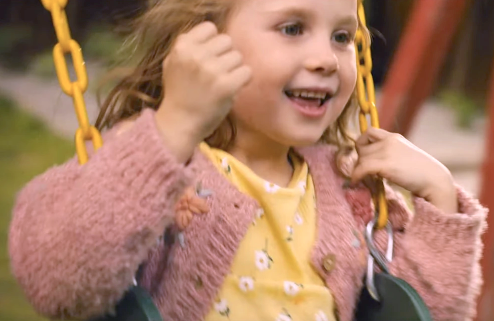 little girl with yellow shirt and pink sweater in Reminders of Him